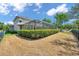 Backyard view of a screened pool behind a manicured, trimmed hedge and a black metal fence at 5117 Longspur Ct, Lithia, FL 33547