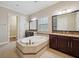 Luxurious bathroom with a soaking tub, granite counters, and dual vanities at 5117 Longspur Ct, Lithia, FL 33547
