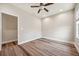 This bedroom features stylish wood flooring and a ceiling fan, with an open doorway to another room at 5117 Longspur Ct, Lithia, FL 33547