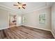 Bedroom with wood floors and ceiling fan, open to en-suite bathroom at 5117 Longspur Ct, Lithia, FL 33547