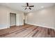 This bedroom features stylish wood flooring, ceiling fan, and a double door closet for storage at 5117 Longspur Ct, Lithia, FL 33547