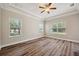 Bright bedroom featuring wood floors, a ceiling fan, and multiple windows at 5117 Longspur Ct, Lithia, FL 33547