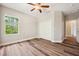 Bright bedroom featuring wood floors, a ceiling fan, and a closet with bi-fold doors at 5117 Longspur Ct, Lithia, FL 33547