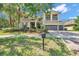 Inviting two-story home featuring a lush lawn, mature landscaping, and a spacious three-car garage at 5117 Longspur Ct, Lithia, FL 33547