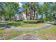 Landscaped yard with sidewalk showing mature trees and green grass surrounding the home's exterior at 5117 Longspur Ct, Lithia, FL 33547