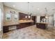 A full kitchen featuring dark wood cabinets, a central island, and granite countertops, is ready for cooking and entertaining at 5117 Longspur Ct, Lithia, FL 33547