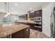 This kitchen features dark wood cabinets, granite countertops, stainless steel appliances and an island at 5117 Longspur Ct, Lithia, FL 33547
