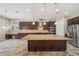 This kitchen features dark wood cabinets, granite countertops, stainless steel appliances and a large kitchen island at 5117 Longspur Ct, Lithia, FL 33547