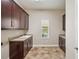 Spacious laundry room with dark wood cabinets, sink and window at 5117 Longspur Ct, Lithia, FL 33547