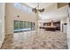 Spacious living room featuring a high ceiling, tile floors, kitchen view, and access to the screened pool area at 5117 Longspur Ct, Lithia, FL 33547