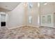 Large living room features soaring ceilings, a tiled floor, and large front doors for ample natural light at 5117 Longspur Ct, Lithia, FL 33547