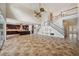 Bright living room featuring stairs leading to the second floor, a ceiling fan, and an open concept layout at 5117 Longspur Ct, Lithia, FL 33547