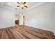 Light-filled main bedroom with ceiling fan, wood floors, and a view into the ensuite bathroom at 5117 Longspur Ct, Lithia, FL 33547