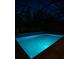 A screened-in pool with in-pool lighting illuminates the water at night at 5117 Longspur Ct, Lithia, FL 33547