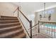 Elegant staircase with carpeted steps and white railings leads to an open landing overlooking the pool at 5117 Longspur Ct, Lithia, FL 33547