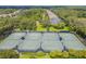 Aerial view of well-maintained community tennis courts, surrounded by lush greenery and manicured lawns at 5117 Longspur Ct, Lithia, FL 33547