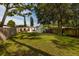 A spacious backyard featuring a shed, lush grass, and mature trees creating a serene outdoor space for relaxation and entertainment at 5527 Kelly N Dr, St Petersburg, FL 33703