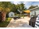 Backyard featuring a cozy lounge area, dining set, storage shed, and shaded by a large sun sail at 5527 Kelly N Dr, St Petersburg, FL 33703