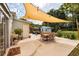 Outdoor patio with dining and seating area, shade canopy, and lush landscaping at 5527 Kelly N Dr, St Petersburg, FL 33703