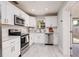 Modern kitchen with stainless steel appliances, white cabinets, and subway tile backsplash at 5527 Kelly N Dr, St Petersburg, FL 33703