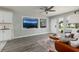 Open-concept living room with modern gray flooring, neutral walls, and a large screen television at 5527 Kelly N Dr, St Petersburg, FL 33703