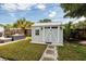 Backyard shed with double doors and a window, offering additional storage or workspace in a landscaped backyard at 5527 Kelly N Dr, St Petersburg, FL 33703