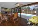 A covered, screened-in deck includes wooden patio furniture and ceiling fans, enhancing outdoor living near the pool at 5717 60Th N Way, St Petersburg, FL 33709
