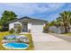 Charming home features a one-car garage, a driveway, and a welcoming front porch with well-manicured landscaping at 5717 60Th N Way, St Petersburg, FL 33709