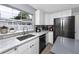 Well-lit kitchen features white cabinets, gray countertops, stainless steel appliances, and a large window at 5717 60Th N Way, St Petersburg, FL 33709