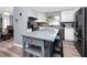 Modern kitchen featuring stainless appliances, gray island, and hardwood flooring at 5717 60Th N Way, St Petersburg, FL 33709