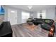 Cozy living room features modern flooring, a leather sectional sofa, and a wall-mounted television at 5717 60Th N Way, St Petersburg, FL 33709