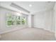 Bright bedroom with three windows providing natural light and neutral carpet flooring at 6605 N Nebraska Ave # 25, Tampa, FL 33604