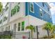 Charming townhome showcasing its modern design, blue accents, and fenced front yard at 6605 N Nebraska Ave # 25, Tampa, FL 33604