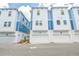 Modern townhome exterior showcasing blue and white facade and attached garages at 6605 N Nebraska Ave # 25, Tampa, FL 33604