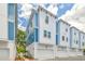 Modern townhome exterior showcasing blue and white facade, landscaping and attached garages at 6605 N Nebraska Ave # 25, Tampa, FL 33604
