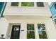 Front view of the home showcasing modern design with clean lines, windows, and covered entry at 6605 N Nebraska Ave # 25, Tampa, FL 33604