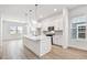 Open-concept kitchen with stainless steel appliances, quartz counters, an island, and wood flooring at 6605 N Nebraska Ave # 25, Tampa, FL 33604