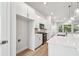 Modern white kitchen offers stainless steel appliances, quartz countertops, and wood flooring at 6605 N Nebraska Ave # 25, Tampa, FL 33604