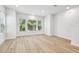Spacious living room with three large windows, providing ample natural light, and wood flooring at 6605 N Nebraska Ave # 25, Tampa, FL 33604