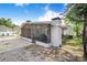 The exterior of a home featuring a screened-in porch with a grill and backyard at 6704 N Branch Ave, Tampa, FL 33604