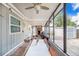 Back porch featuring a ceiling fan, fireplace, and large screened windows at 6704 N Branch Ave, Tampa, FL 33604