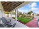 Backyard with dock and canal view and a covered patio with gray Adirondack chairs on the porch at 6805 Arroyo Dr, New Port Richey, FL 34652