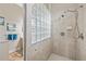Bathroom showing a tiled shower with glass block window and a view of the double vanity area at 6805 Arroyo Dr, New Port Richey, FL 34652