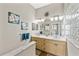 Bright bathroom features a double vanity with framed mirrors, nice wall art, and a glass block window at 6805 Arroyo Dr, New Port Richey, FL 34652