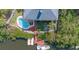 Birds eye view of backyard featuring a sparkling pool, wood dock, and boat lift on the canal at 6805 Arroyo Dr, New Port Richey, FL 34652