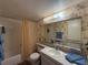 Bathroom featuring a shower-tub combo, floral wallpaper, and a vanity with a large mirror at 7910 Sun Island S Dr # 404, South Pasadena, FL 33707