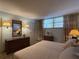 Bedroom featuring neutral tones, a comfortable bed, mirrored dresser, and natural light at 7910 Sun Island S Dr # 404, South Pasadena, FL 33707