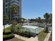View of a community featuring a shuffleboard court, swimming pool, well-manicured green spaces, and towering buildings at 7910 Sun Island S Dr # 404, South Pasadena, FL 33707