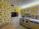 Retro kitchen with yellow appliances, vintage wallpaper, and a pass-through to another room at 7910 Sun Island S Dr # 404, South Pasadena, FL 33707