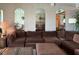 Comfortable living room with a plush brown sectional sofa, mirrored alcoves, and stylish lighting at 7910 Sun Island S Dr # 404, South Pasadena, FL 33707